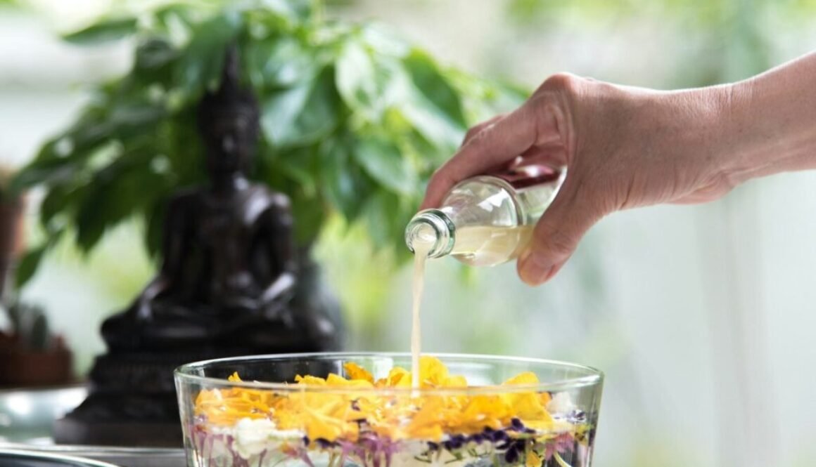 person pouring yellow liquid on clear drinking glass