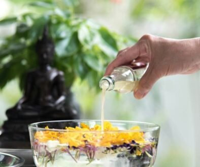 person pouring yellow liquid on clear drinking glass